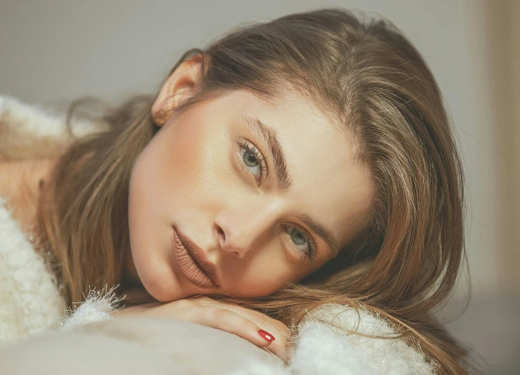 a woman laying down next to a white teddy bear