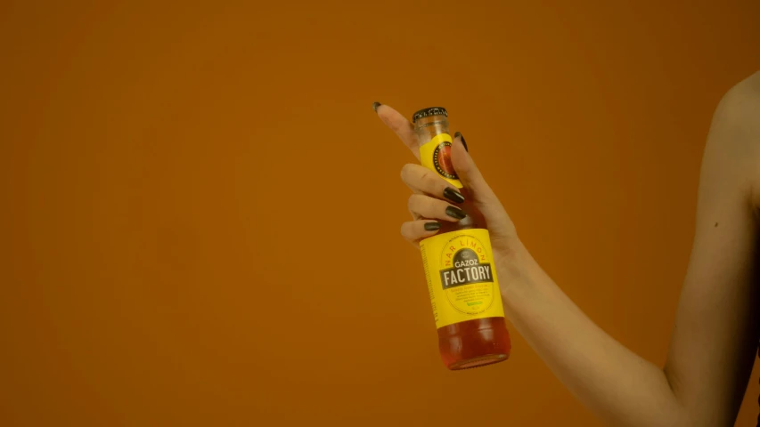 woman holding up a bottle of ketchup next to a cup