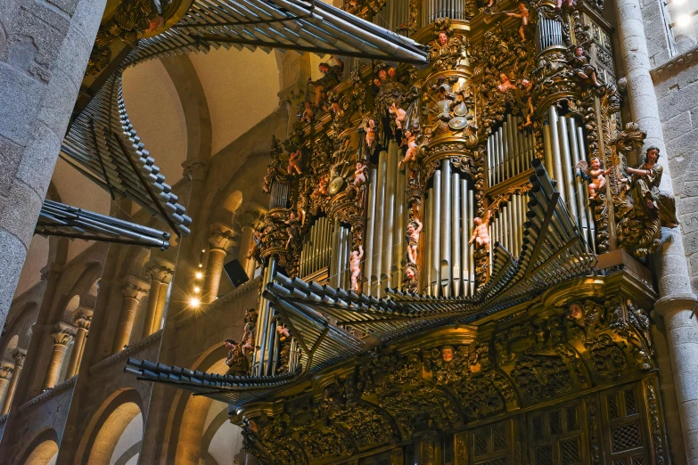 an ornate organ next to a very tall church tower