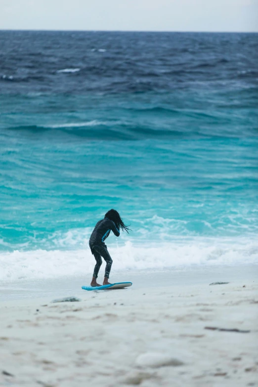 the man is riding his surfboard on the beach