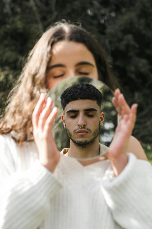 a man and woman holding his hand in front of their faces