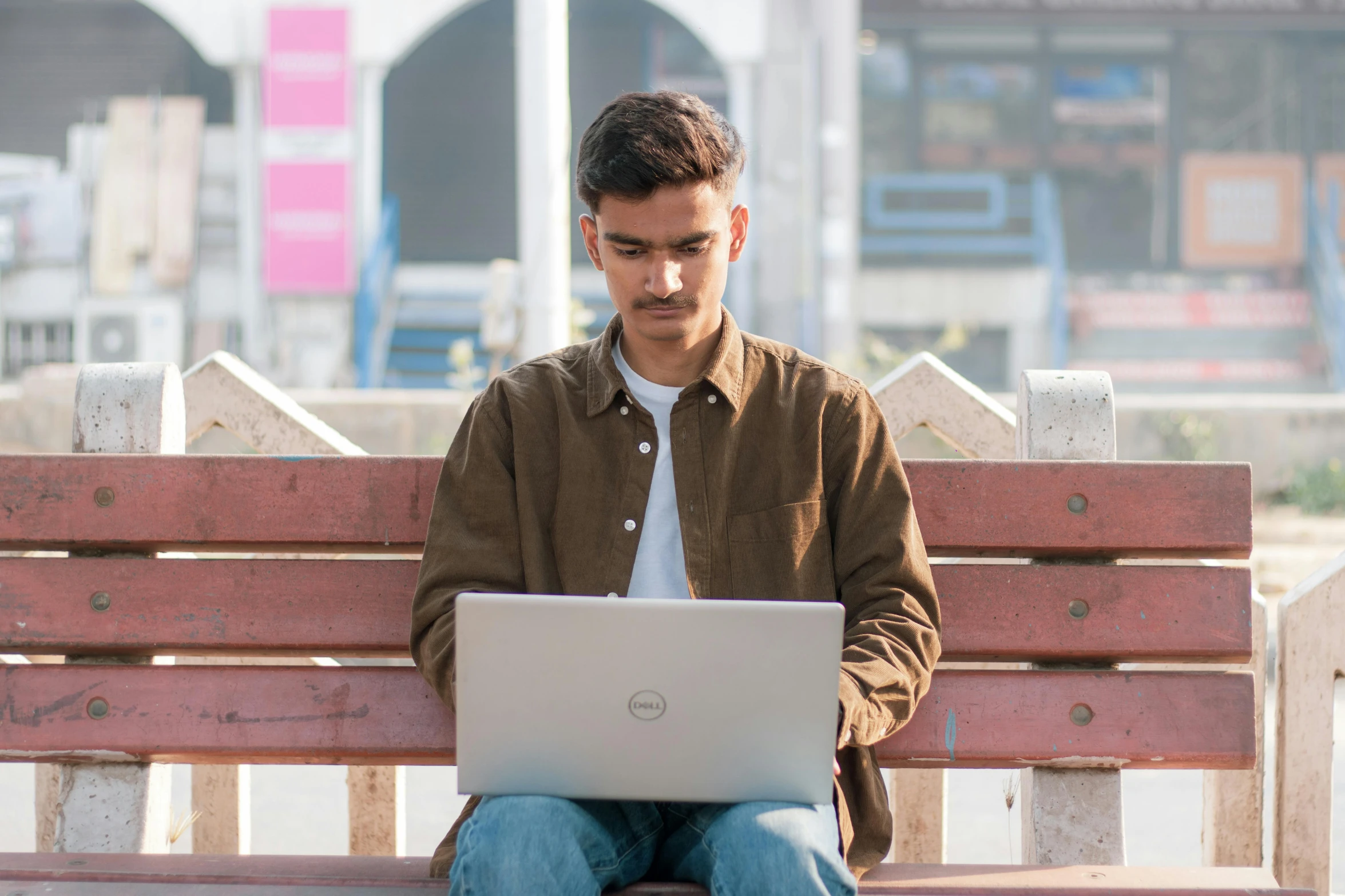 a man on a bench with his laptop