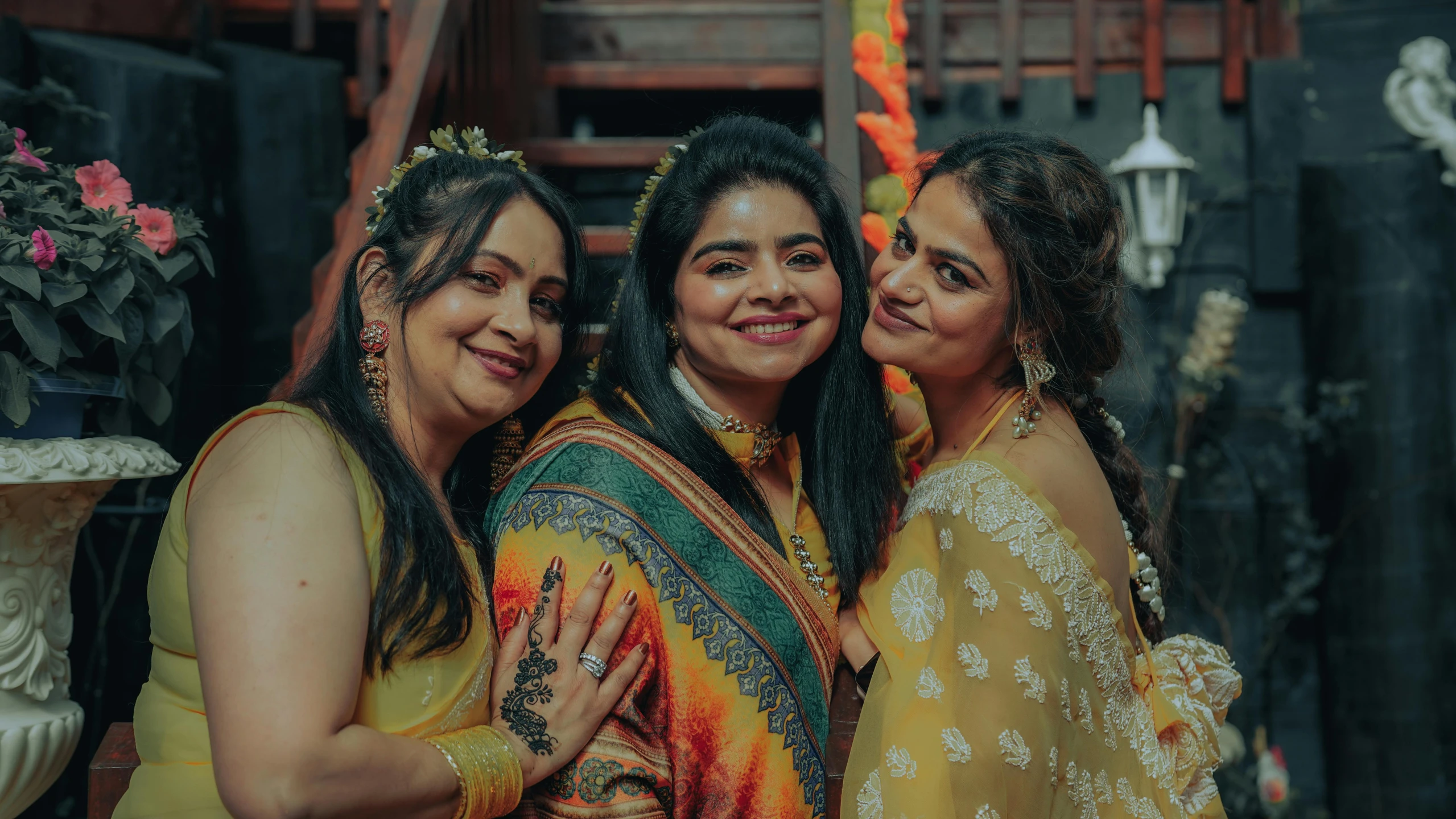 three women pose for the camera with a bouquet of flowers