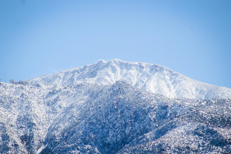 the mountain top is covered in fresh snow