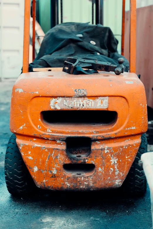 a worn out orange truck with a bag sitting on top