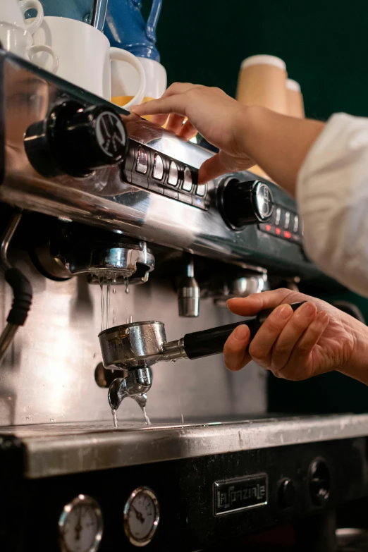 a close up of someone pressing down a beverage from a coffee maker