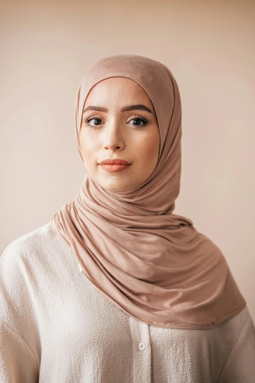 this young woman is wearing a light brown head scarf