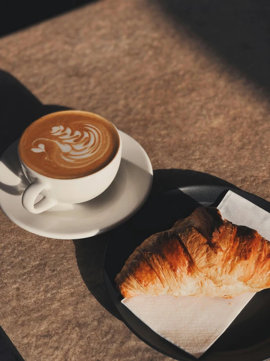 a pastry and cup of coffee sitting on a table