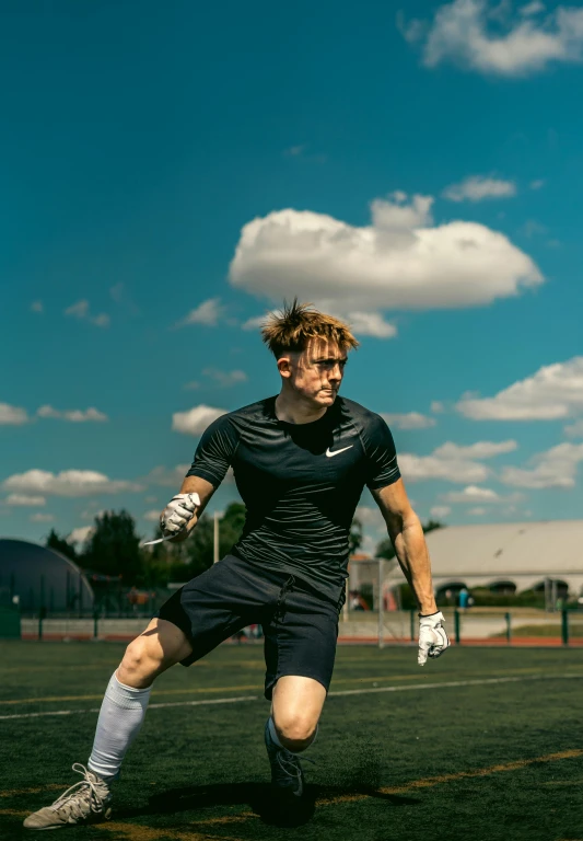 a man in black uniform playing soccer on a field