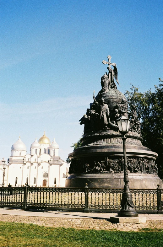 a statue in front of a building with white domes