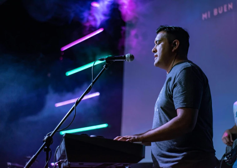 man playing keyboards on stage during a concert