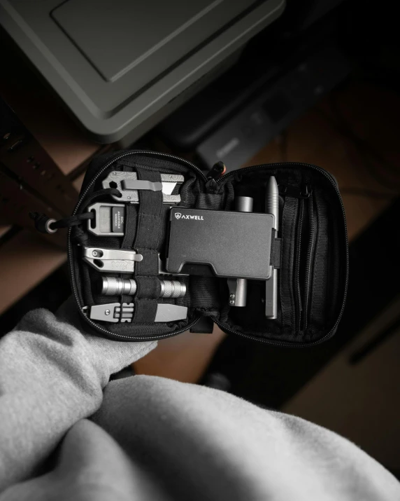 an open pouch containing various electrical devices sitting on a bed