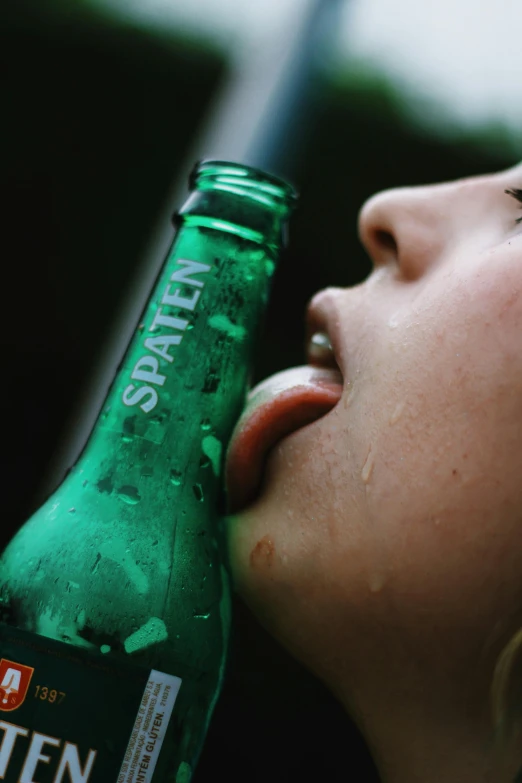 a woman licking a green bottle with it's mouth