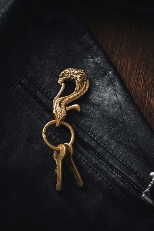 a pair of keys is pinned to the pocket of a jacket