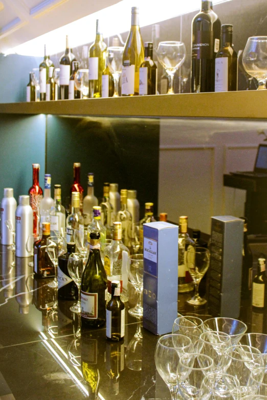 a room full of bottles and glasses next to a shelf