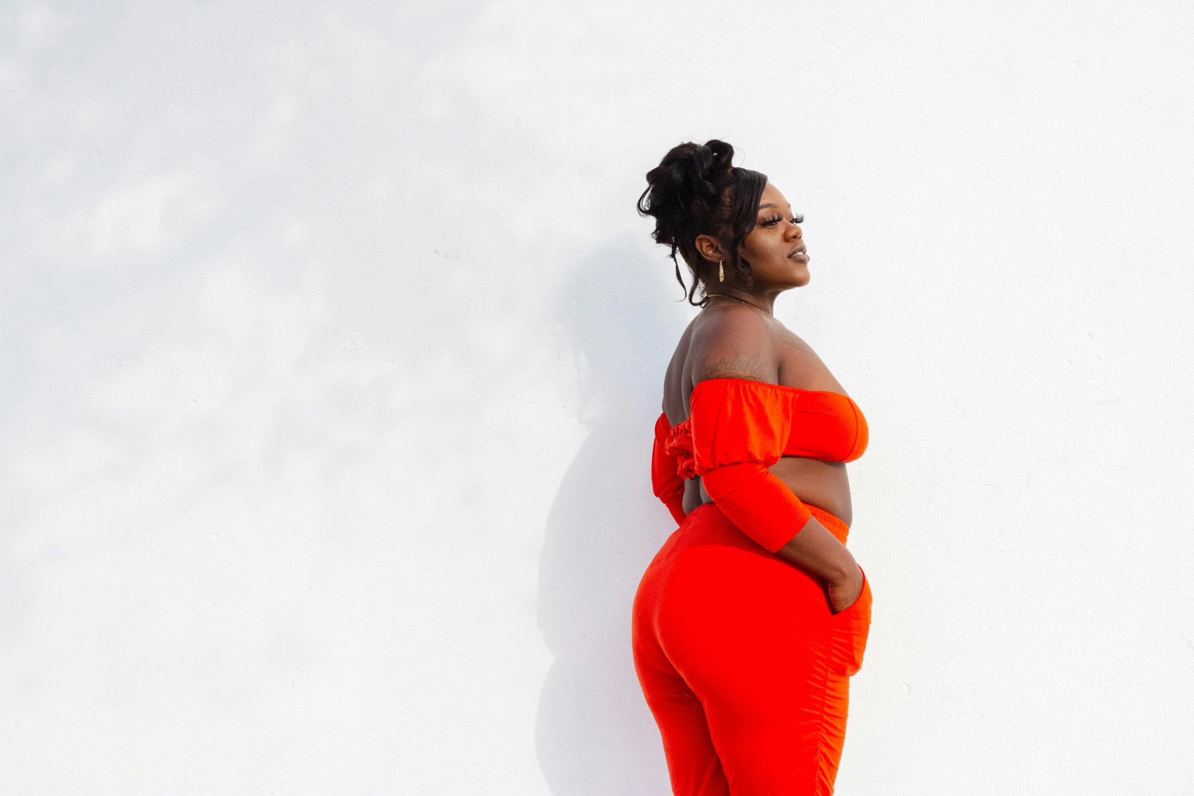 a woman is posing in an orange outfit