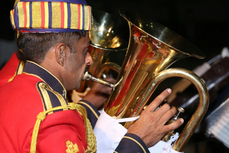 a ss musician playing his instruments while wearing red and gold uniforms