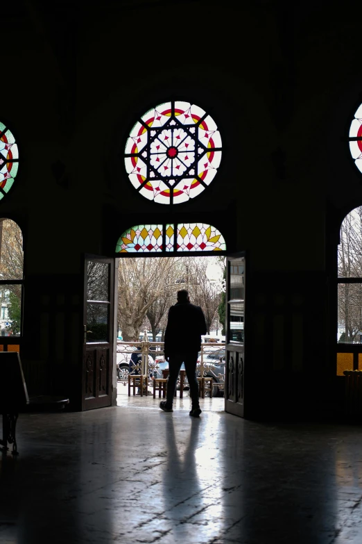 a person with umbrella in front of three round windows