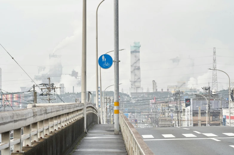 a cloudy day shows a concrete city with an industrial area in the background