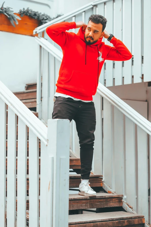 a man standing on stairs in a red hoodie