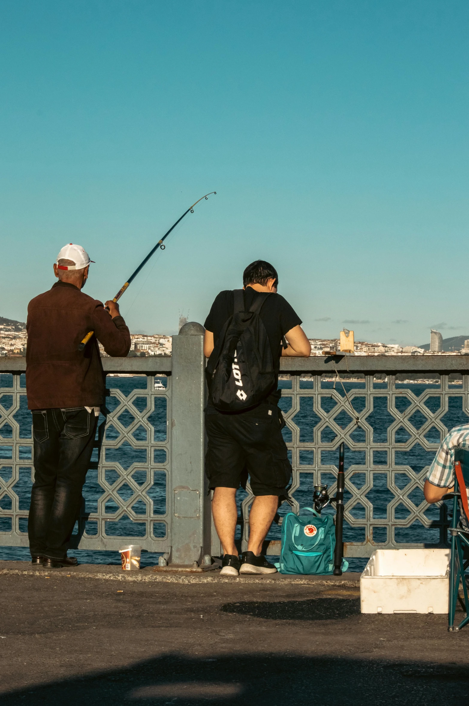 two people are standing and fishing in the city