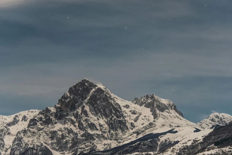 two mountains covered in snow under the moonlight