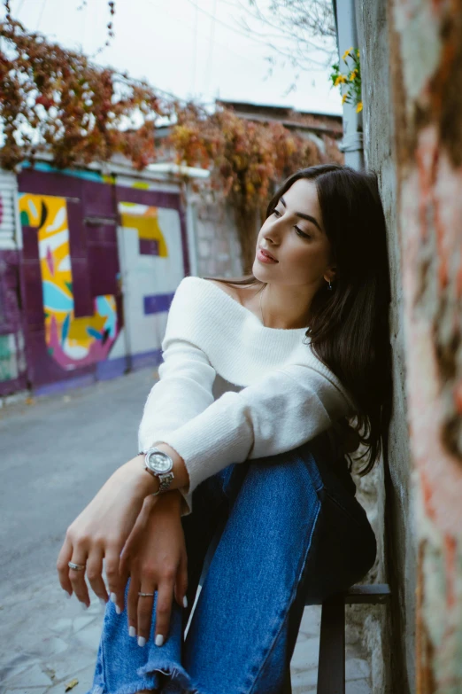 a beautiful woman sitting in a chair next to a wall