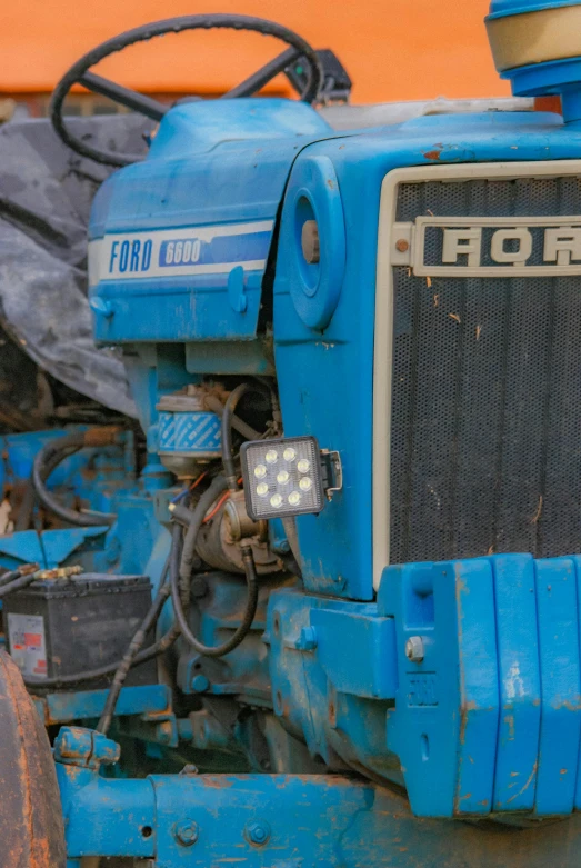 a blue tractor with a front light turned on