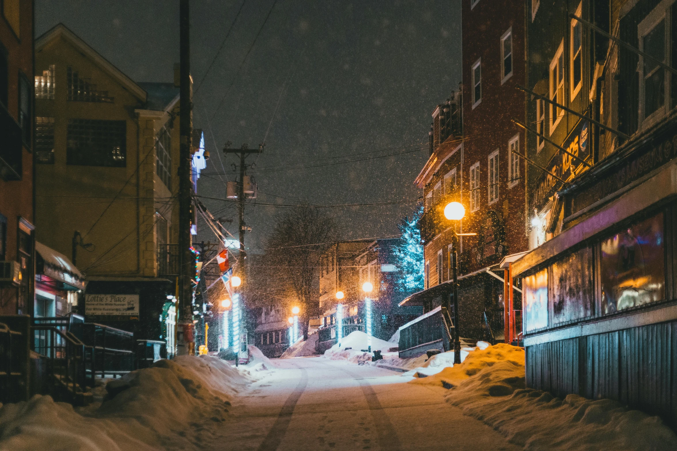 a snowy road between two buildings on a snowy day