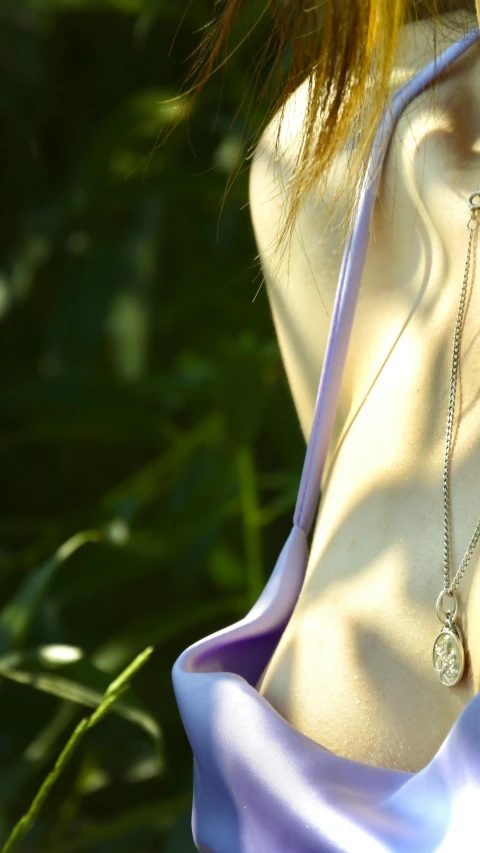 the back of a woman's neck wearing a necklace