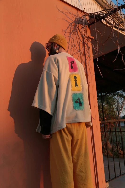 a man with his face covered up against the wall