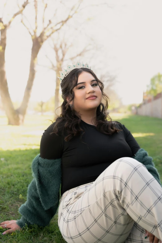 a young woman poses in a green cardigan shirt