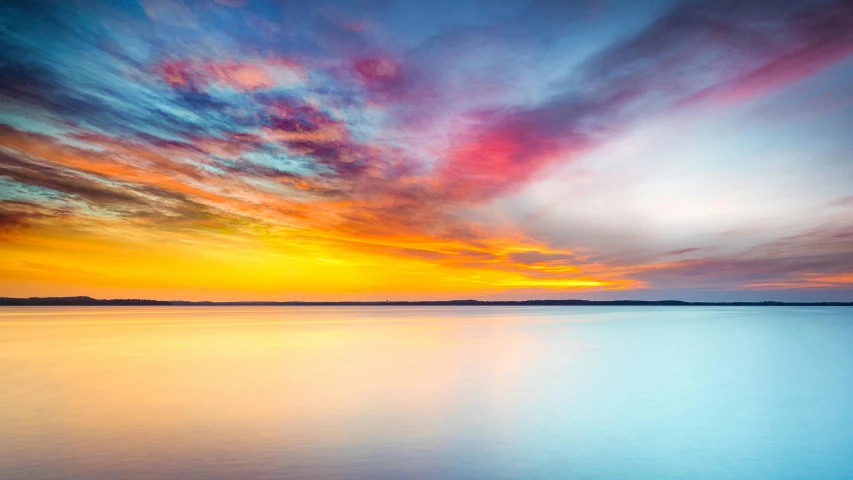 a bright sunset on the ocean with a sky that has clouds