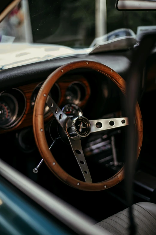 a steering wheel and wood dashboard on an old car