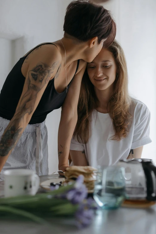 two women are smiling as they look at soing in front of them