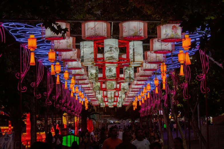 a crowd of people walking past large lighted boxes