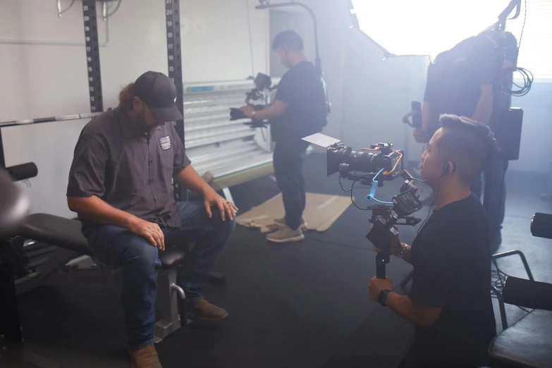 three guys are behind the camera in the recording studio