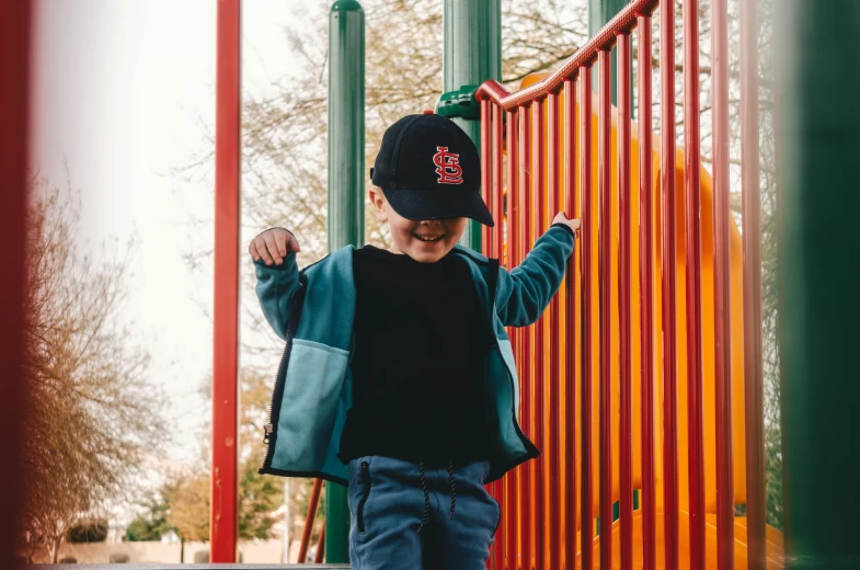 a small boy is standing at the playground