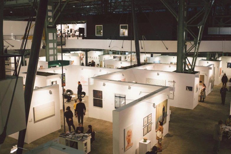 an exhibition in a building surrounded by large white walls