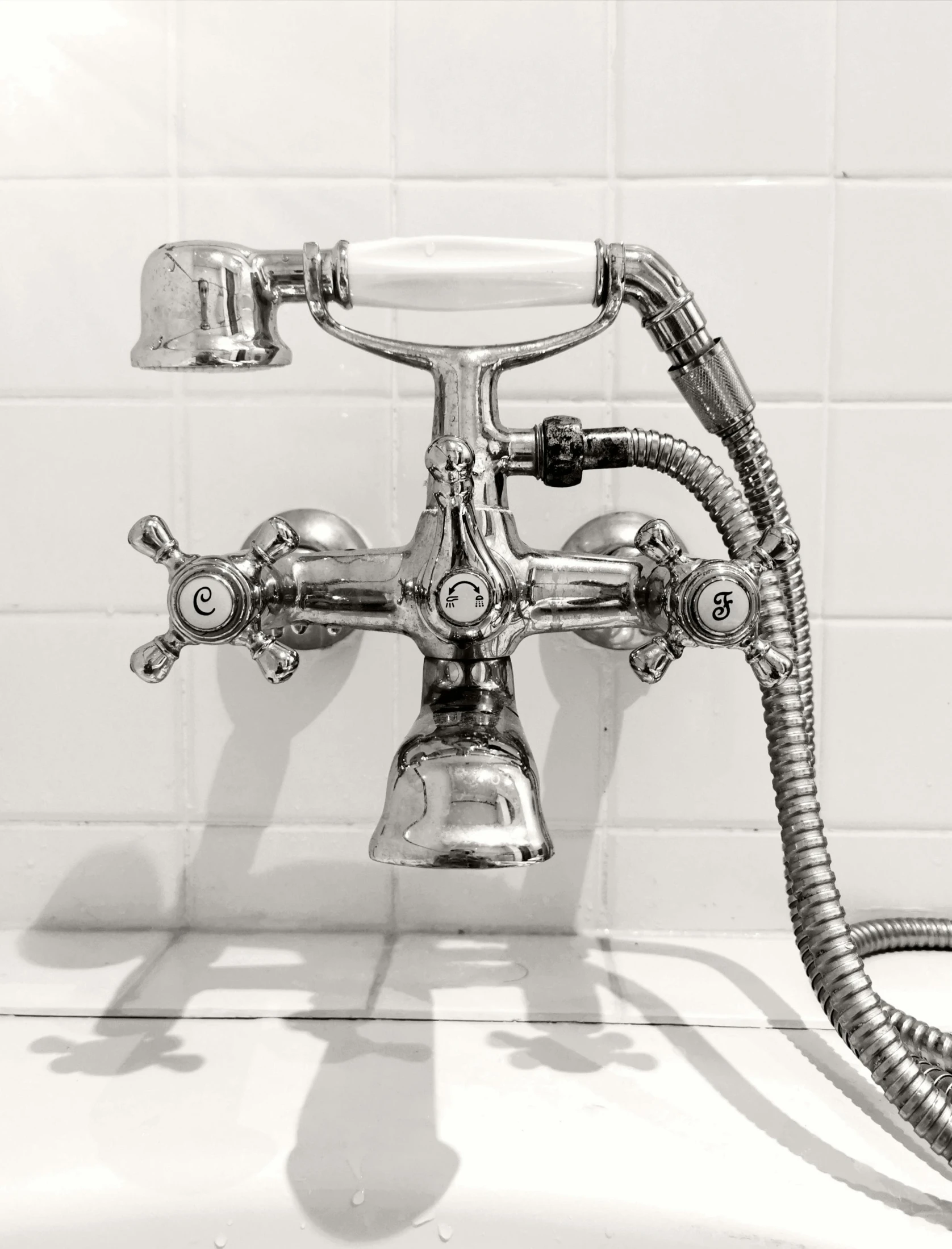 an old fashioned shower faucet sits in a bathroom