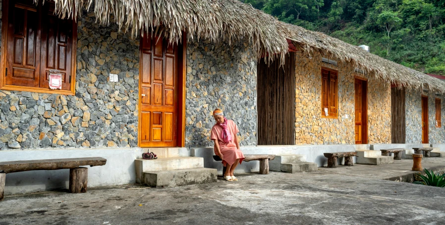 a woman standing on the corner of a street by a row of buildings