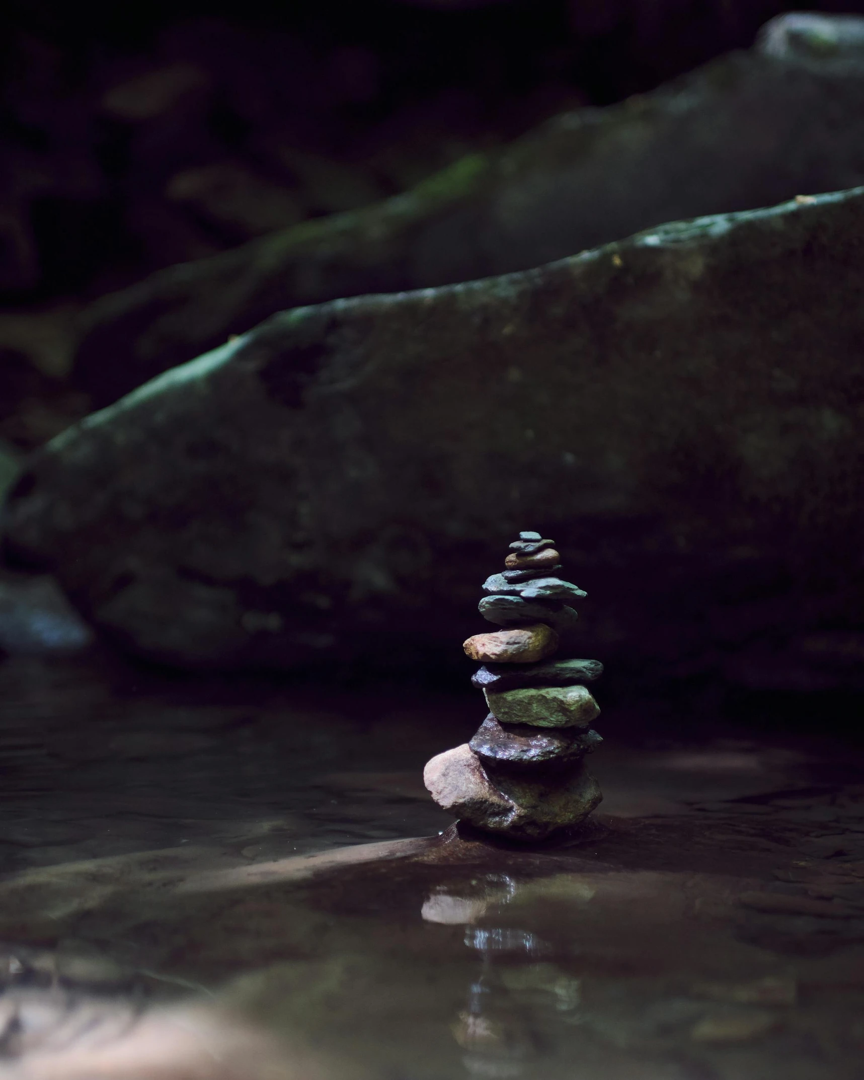 a stack of rocks in water near rocks