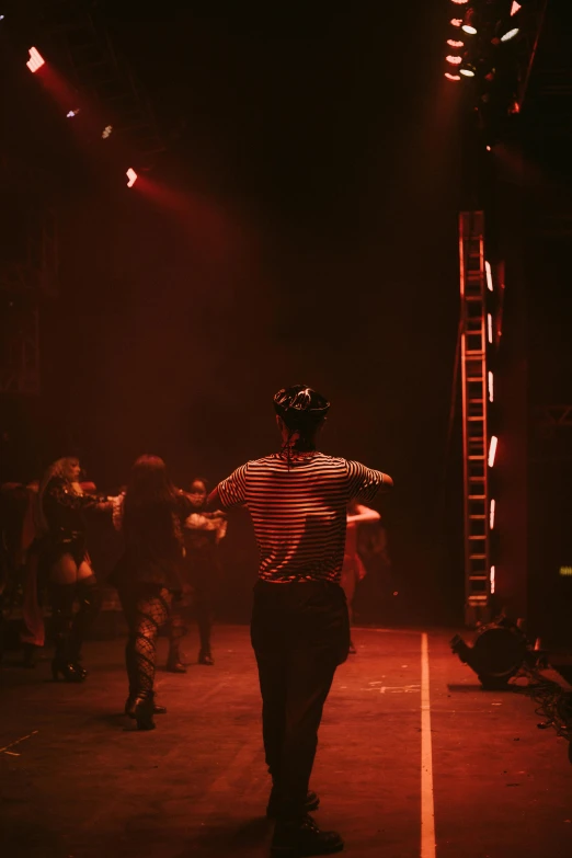 a man with a hat on walking down a runway