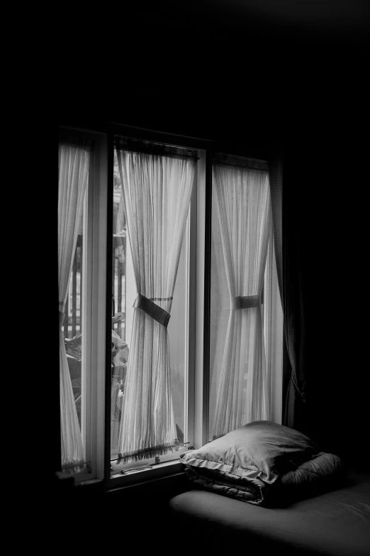 a window with sheer curtains and a blanket on it