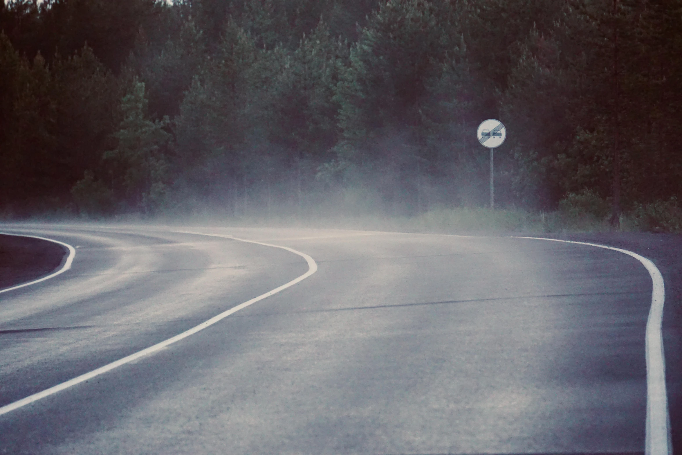 a car driving on a road in the rain