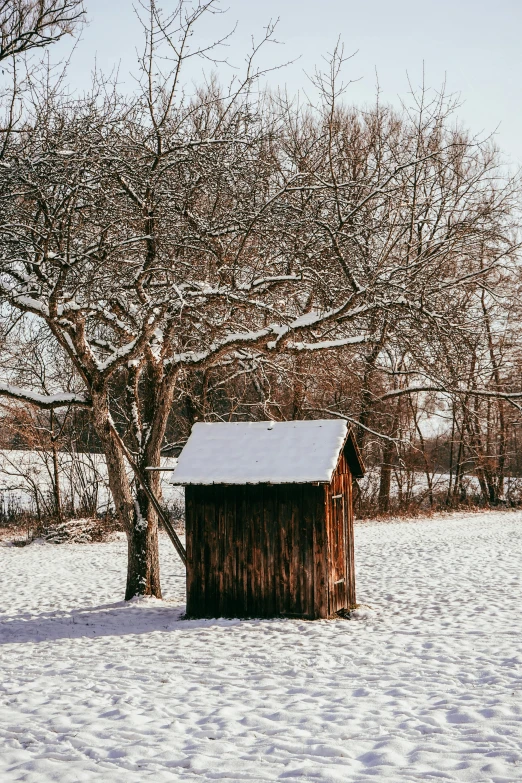 an outhouse on a field covered in snow
