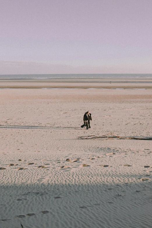 two people with a surfboard on the beach