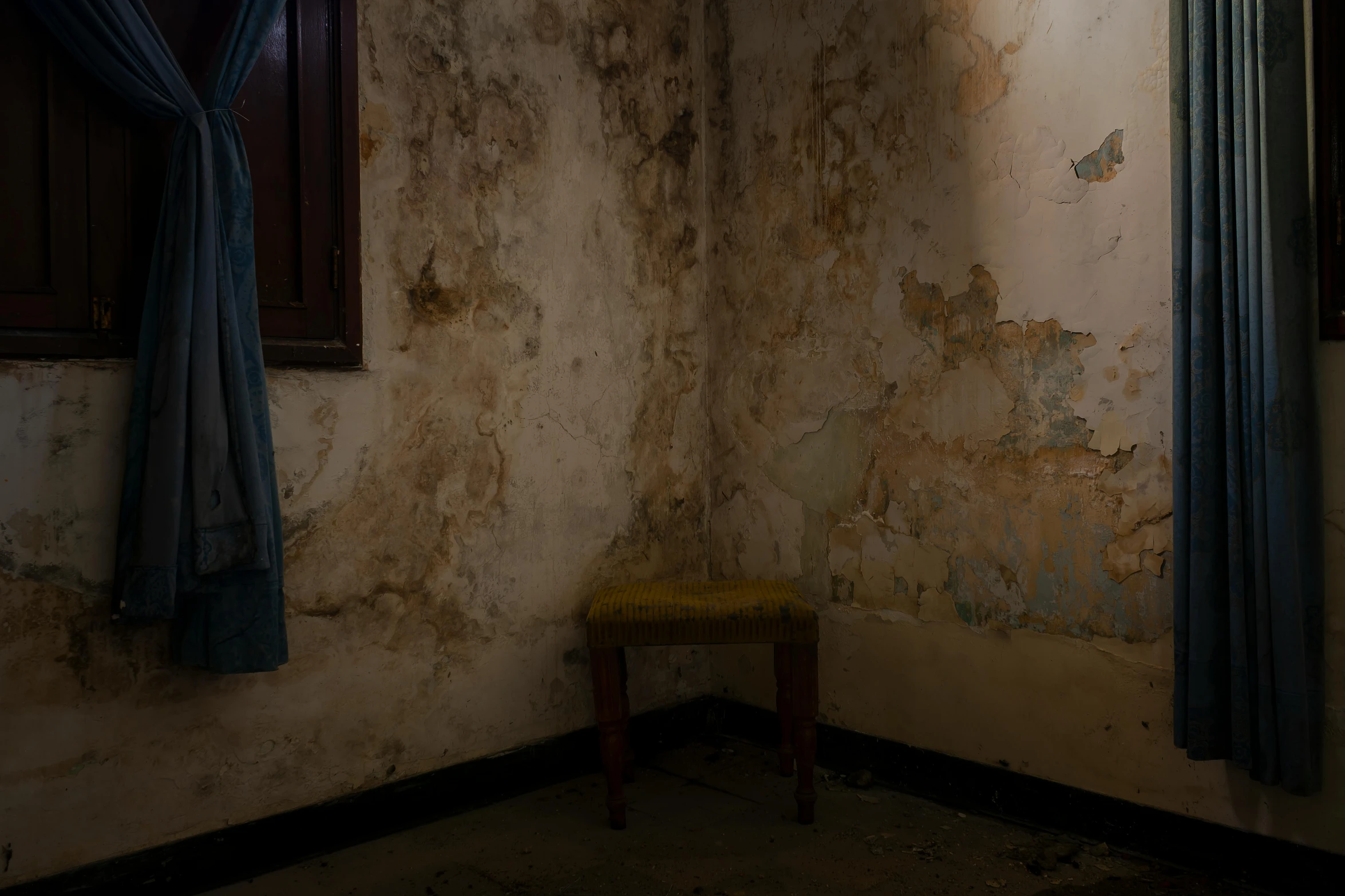 a room with peeling paint and wooden window frames