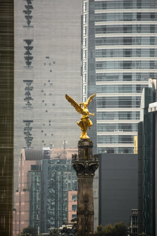 a golden eagle statue is in front of tall buildings