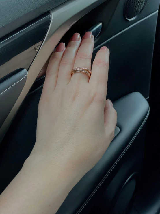 person in car wearing a diamond band on their wedding ring